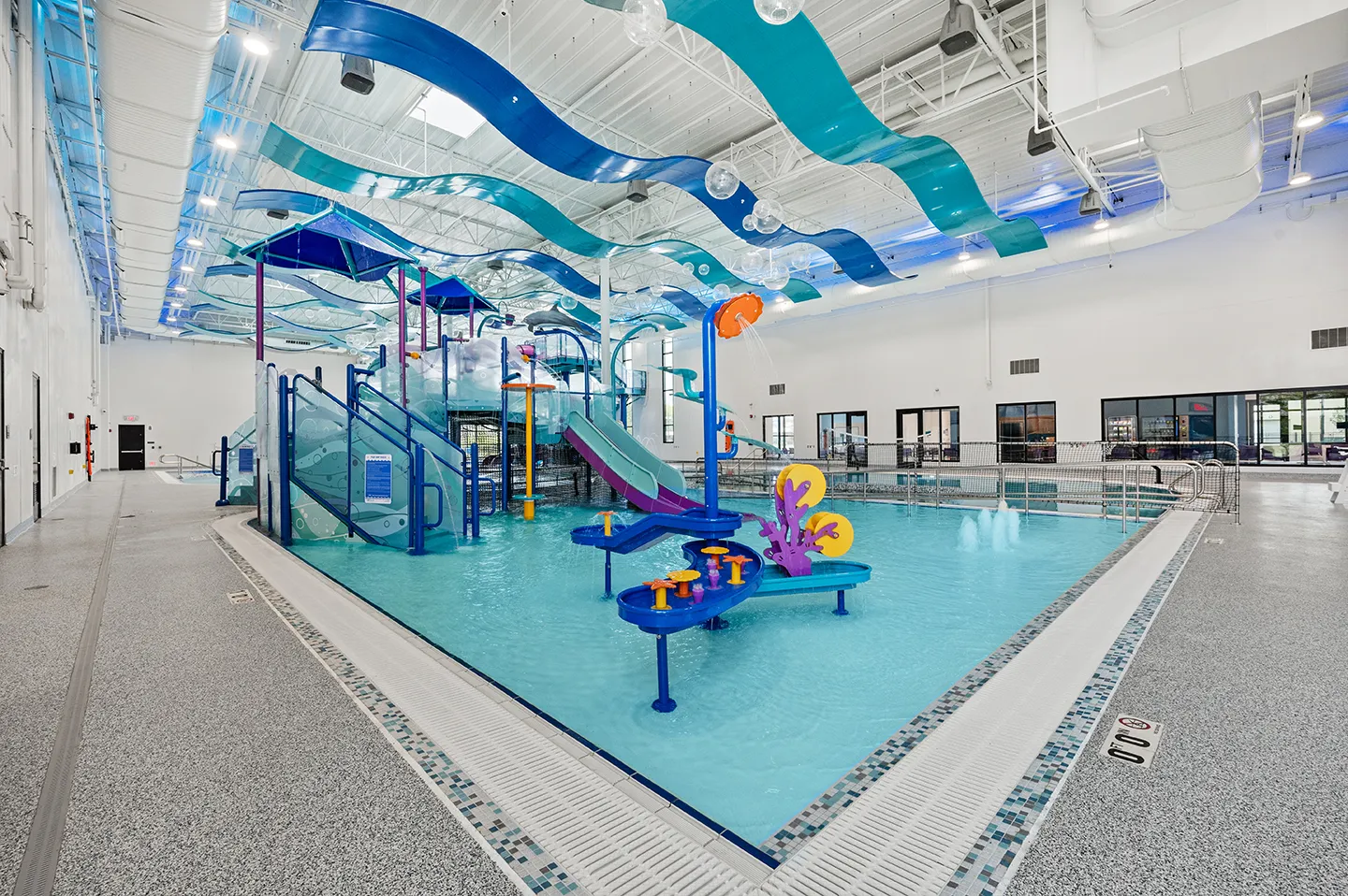 The center features an 11,400-square-foot natatorium, which includes a large internally lit water slide, a zero-depth entry zone for wheelchair accessibility, and access to a tiered play feature.